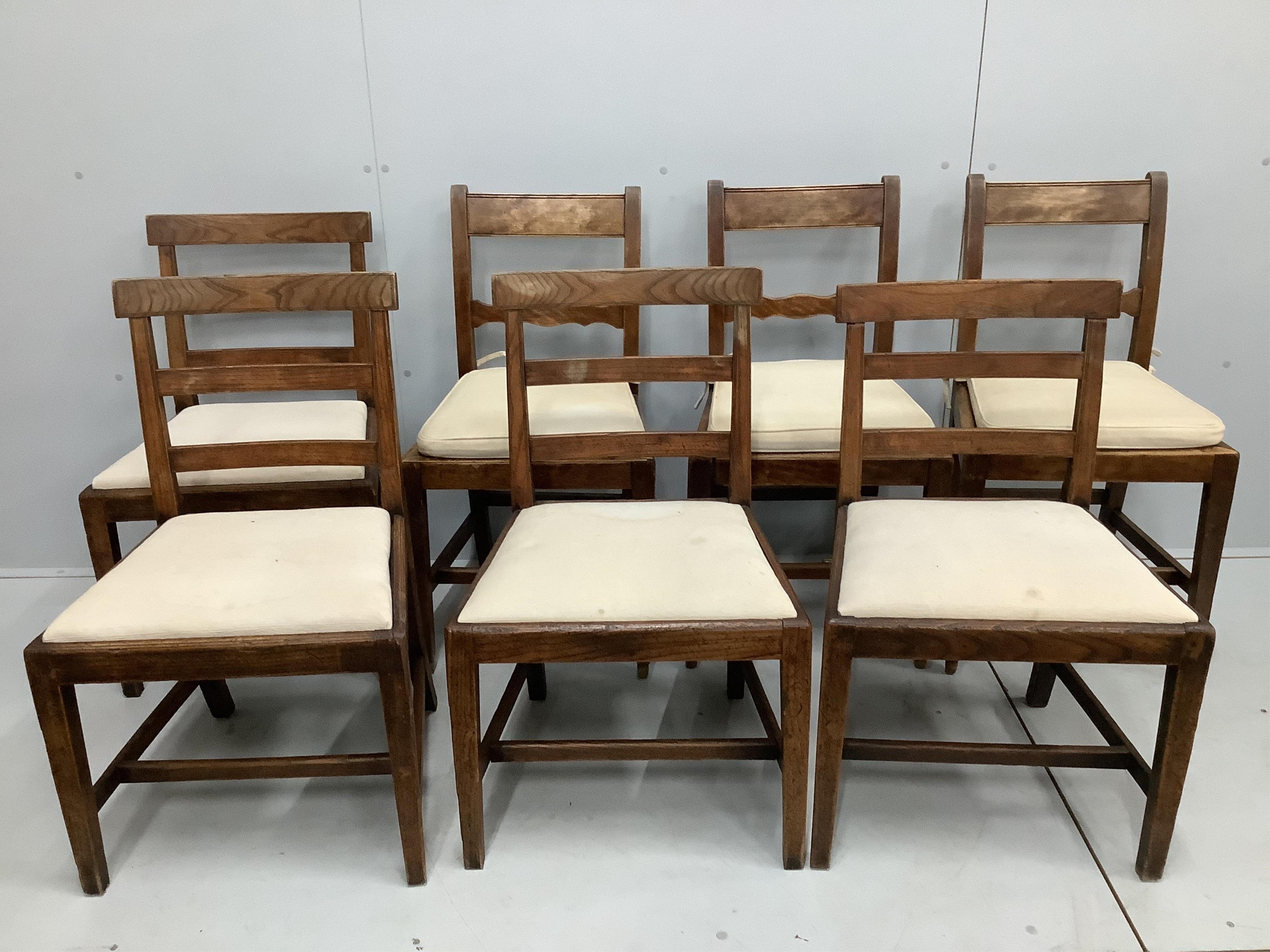 A harlequin set of seven early 19th century provincial elm and fruitwood dining chairs